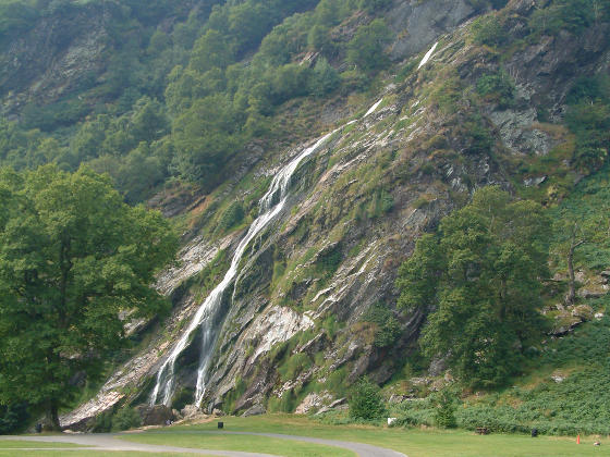Water coming down a rocky hillside with trees around